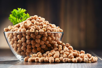 Composition with bowl of chickpeas on wooden table