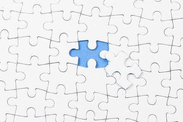 Fototapeta premium Blue background made from white puzzle pieces and place for your content 