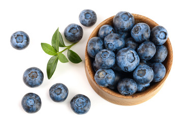 fresh ripe blueberry with leaf in wooden bowl isolated on white background. Top view. Flat lay pattern