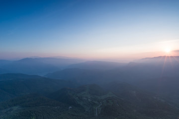 Sunset panorama of successive mountains sun bathed close to sunset time without clouds but some tiny sun rays at Catalonia, Spain