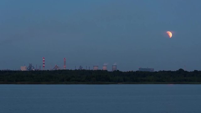 Panoramic view of moon eclipse over the industrial zone in Dabrowa Gornicza, Poland. Timelapse