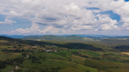 Fototapeta na wymiar aerial view on forest and fields and small village in distance 