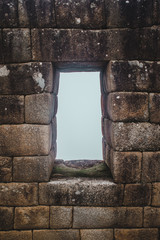 Perfectly preserved ancient stone Inca house with a window on a misty early morning at Machu Picchu
