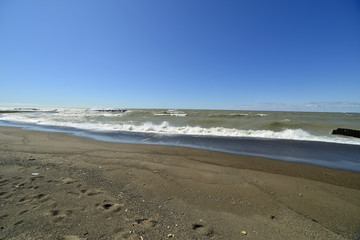 Waves crashing on the sandy shoreline of lake Erie