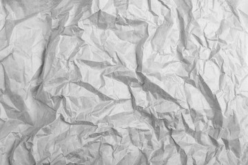 highly crumpled gray paper sheet with dents