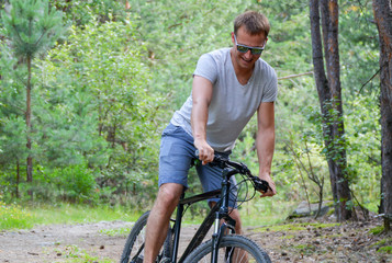 athlete on a bike in a coniferous forest.Healthy lifestyle.Walking by bike
