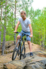 Fototapeta na wymiar athlete on a bike among the rocky terrain.Healthy lifestyle.Walking by bike