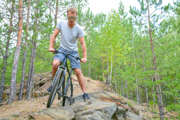 athlete on a bike among the rocky terrain.Healthy lifestyle.Walking by bike