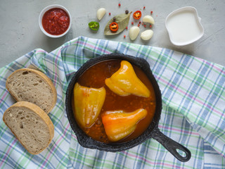 Stuffed peppers on an old frying pan with sour cream.