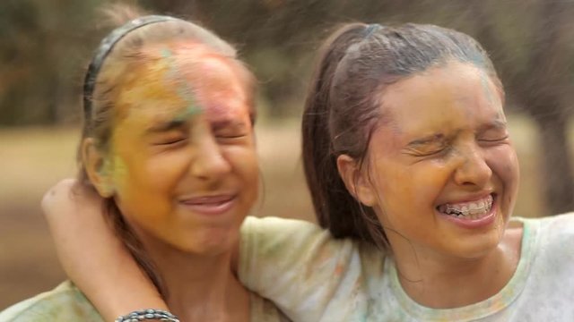 With children wash away the colored powder holi with water. Rest in a recreation park. Smiles, fun, joy of children