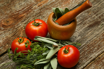 Fresh harvested tomatoes and herbs on the wooden table. Healthy organic nutrition concept. 
