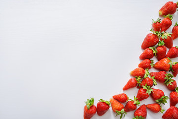 strawberry fruits on the right side on wooden background with copy space. View from above.