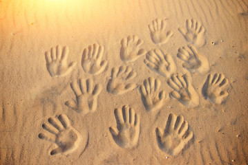 lots of hand prints on the sand