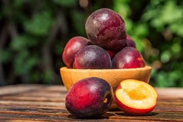 Pluot, mix of plum and apricot in wooden bowl