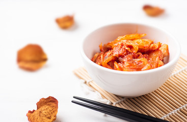 Kimchi cabbage in a bowl with chopsticks, Korean food
