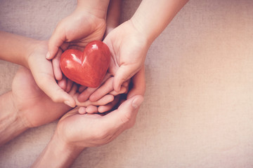 adult and child hands holding red heart, health care, love, organ donation, family insurance and CSR concept, world heart day, world health day, world hypertension day