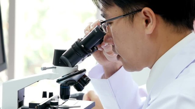Scientist using microscope for work. Male Scientist working at laboratory. People with medical, science, doctor, healthcare concept. 4K Resolution.