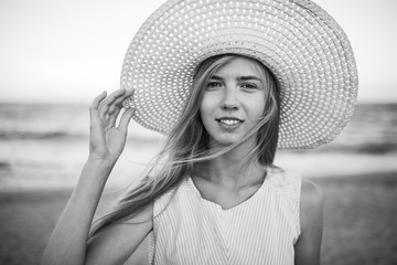 Beautiful portrait of a girl in a hat, rest on the sea or ocean, black and white