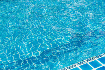 Swimming pool, clear blue water and pool edge.