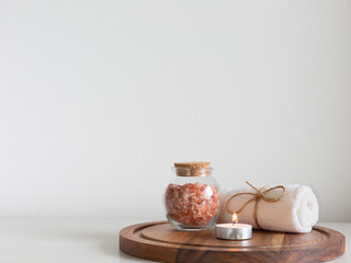 Pink Himalayan salt and towel on wooden plank