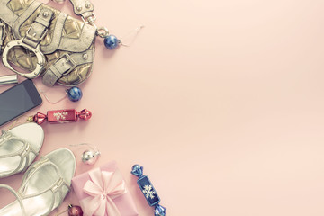 Christmas background pink Flat Lay fashion accessories handbag sandals phone gift box bow balls.
