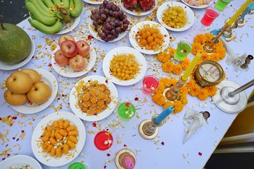 Top view of holy worship with Thai dessert, colorful water, fruit, flowers and candle to worship on the table, Religion concept