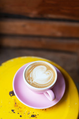 A cup of cappuccino on the old yellow table