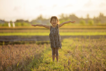 toddler girl playing around the field