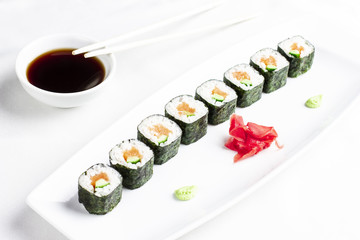 Japanese sushi rolls with salmon and cucumber avocado on white background