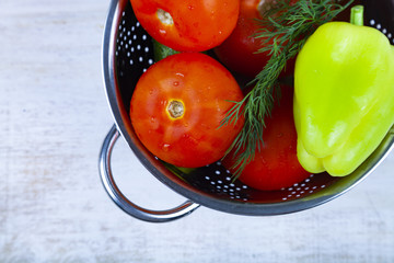 Tomatoes, peppers and cucumbers in a colander