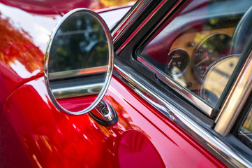 Side mirror of a vintage red car