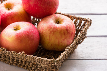 Close up of Red apples in basket on wooden table