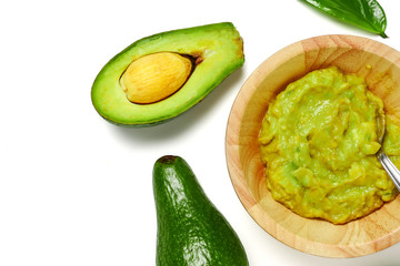 Top view of avocado with guacamole sauce on white background.