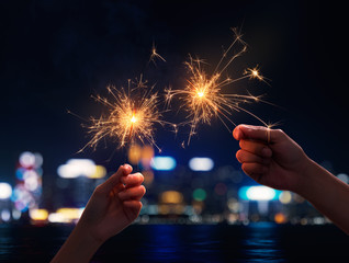 Couple holding a sparklers during nigh time city