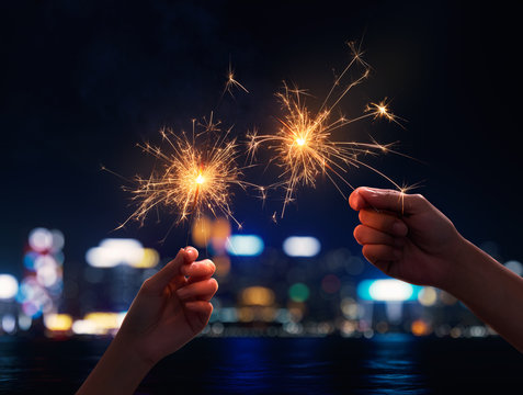Couple holding a sparklers during nigh time city
