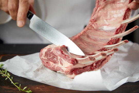 Butcher preparing uncooked lamb chops