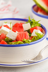Watermelon and feta cheese salad in white plate on a white background.