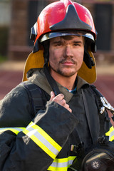 Fototapeta premium Portrait of a young fireman on the background of a fire truck