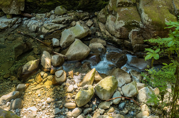 Naklejka na ściany i meble top view of water rushing through the creek below the canyon