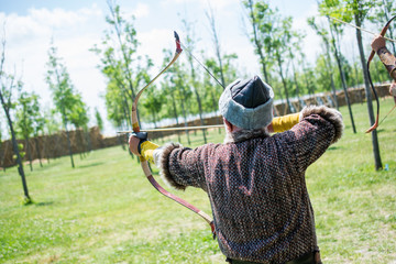 Archer in traditional clothes shooting an arrow
