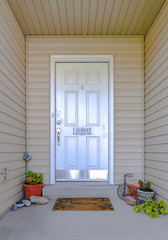White front door with plants and welcome mat