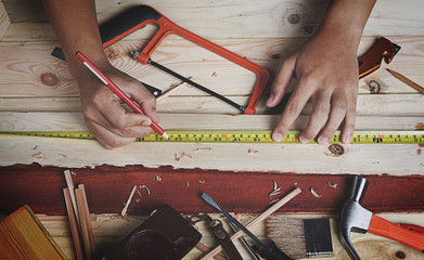 Top View of Carpenter Working in Woodworking Workshop. Measuring Planks of Wood
