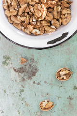 Walnuts on old plateau over a green wooden table