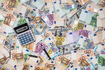Fototapeta na wymiar pile od dollar and euro bills with calculator