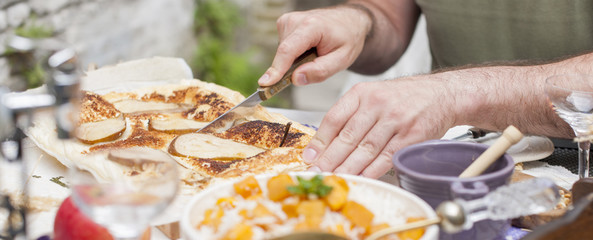 rice with pumpkin and honey on the table and other autumn food, pie with pear. Delicious family dinner in the courtyard. Men's hands cut the cake. Copy space, Banner,