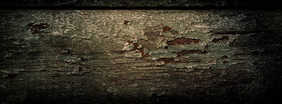 wooden board is covered with old paint and traces of whitewash.