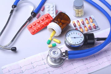 Close-up stethoscope lying on RX prescription with assorted pills. Healthy life or insurance...