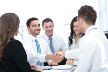 Two handsome men shaking hands with smile while sitting on the c