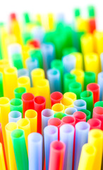 Many colourful plastic straws in a shallow depth of field and bright background
