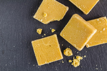 Fudge squares and crumbs isolated on black slate background